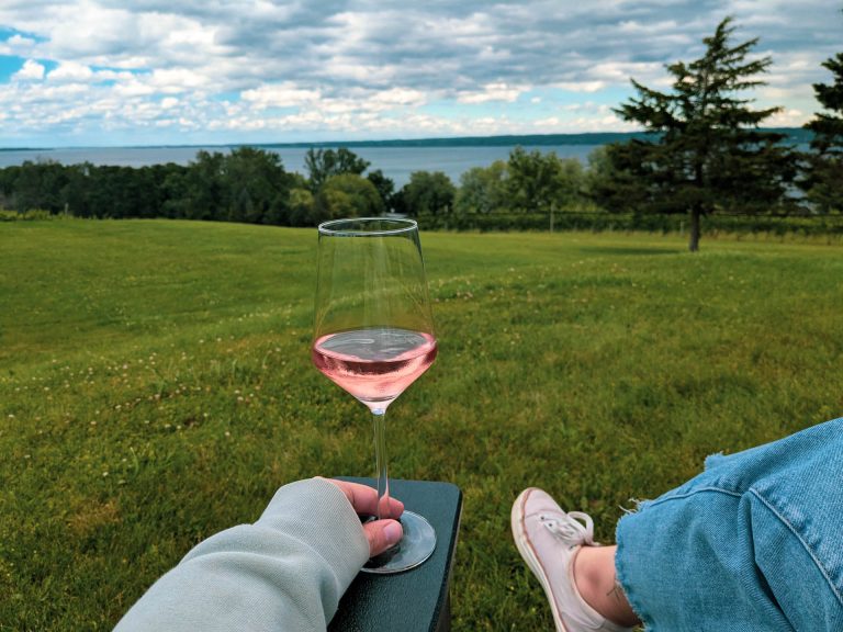 A glass of ros&eacute; wine with a view of Cayuga Lake from the patio at Six Eighty Cellars